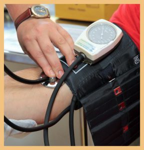 Health worker checking patient's blood pressure signifying integrated healthcare