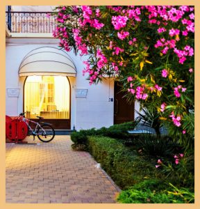 Hotel entrance with flower trees signifying hospitable places