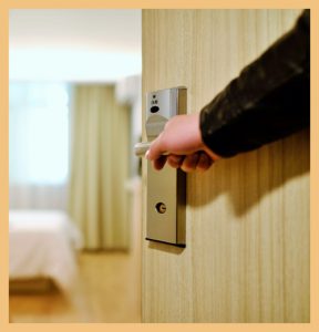 Hotel staff's hand opening a door signifying welcoming gestures