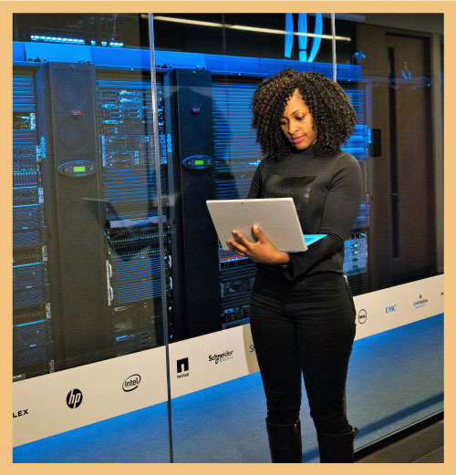 Person in front of computer mainframe signifying high quality operations people transforming performance